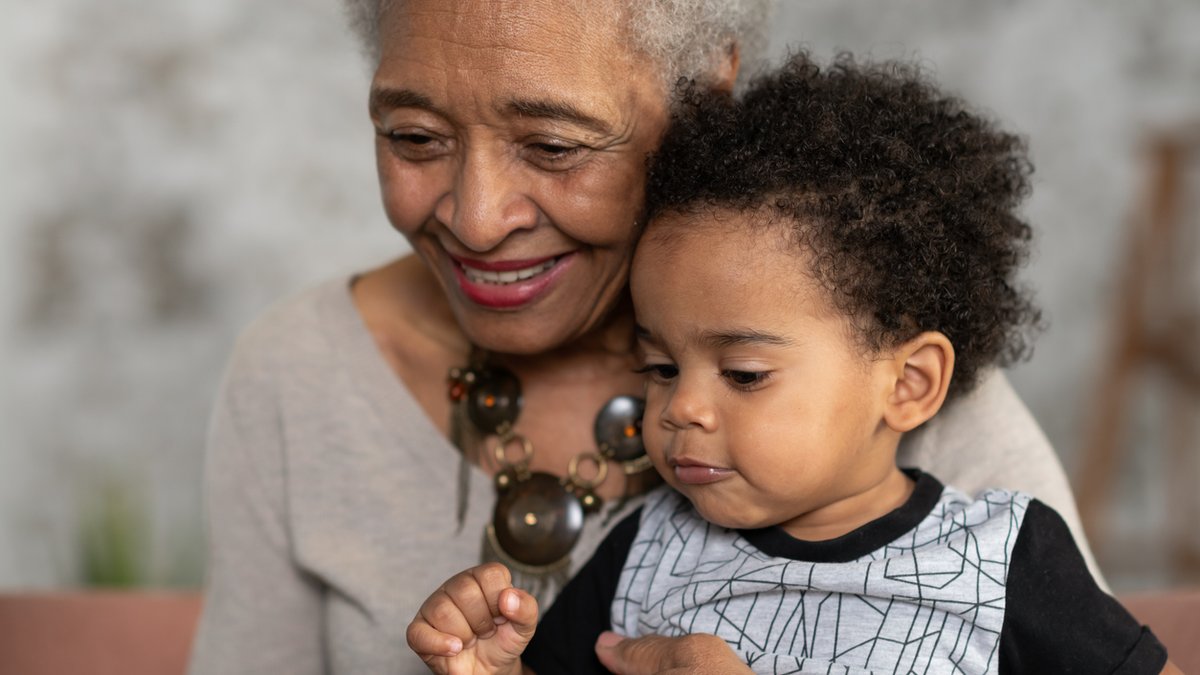 A photo of an older woman and a baby looking towards the same out-of-frame point